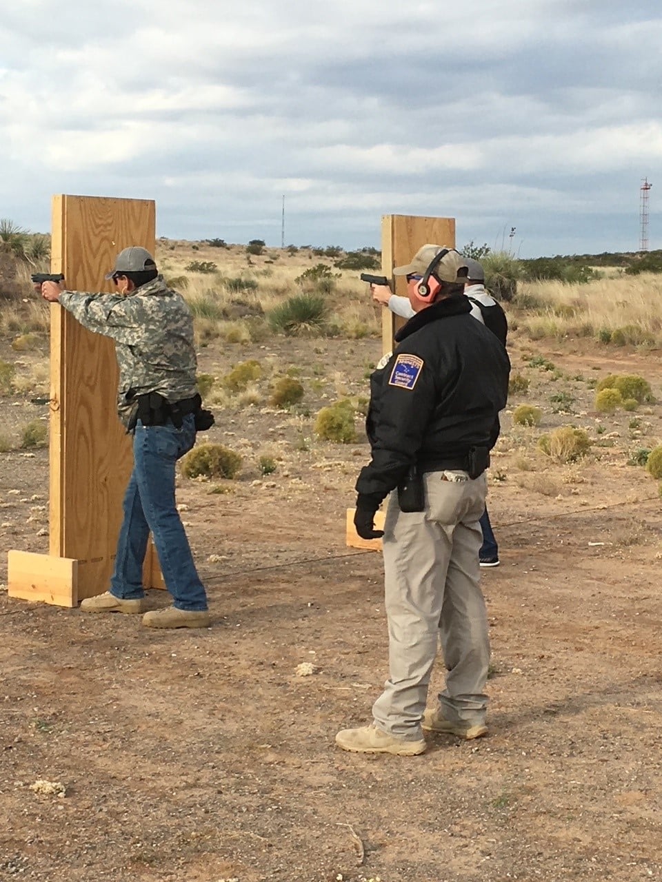 Men shooting handguns at a shooting range